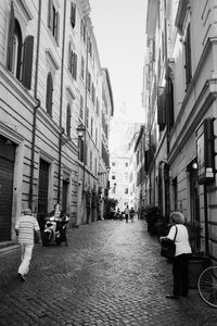 Rear view of people walking on street in city