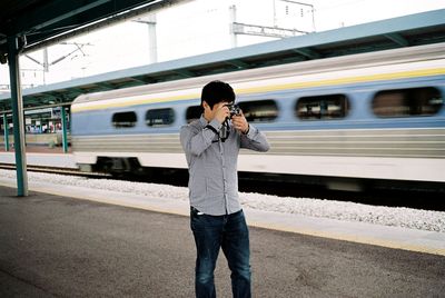 Man photographing at railroad station platform