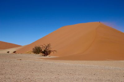 Scenic view of desert against clear blue sky