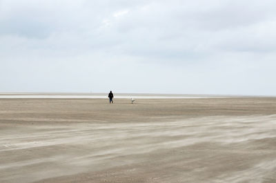 Man standing at beach against sky