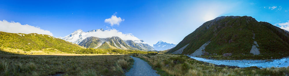 Panoramic view of snowcapped mountains against blue sky