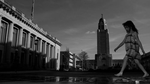 Girl standing against nebraska state capitol building 