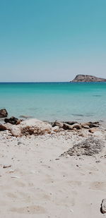 Scenic view of beach against clear blue sky