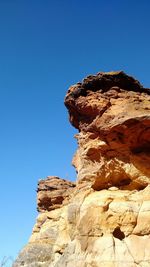 Low angle view of rock formation against blue sky