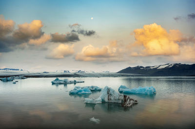 Panoramic view of frozen lake against sky during sunset