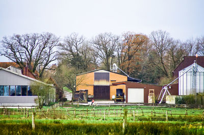 House by barn against clear sky
