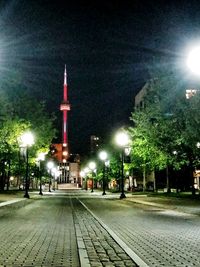 Illuminated street light against sky at night