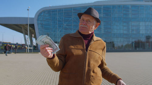 Full length of man standing against glass wall