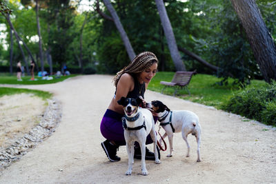 Woman with braids playing with her dogs in the park