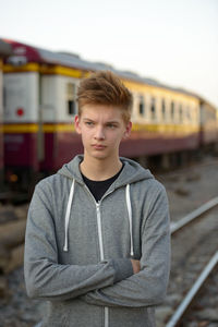 Portrait of young man standing by train