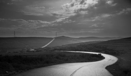 Road by landscape against sky