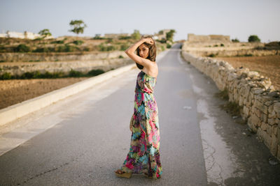 Woman standing on road against sky