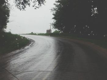 Empty road along trees