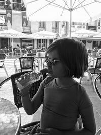 Rear view of cute girl sitting at restaurant