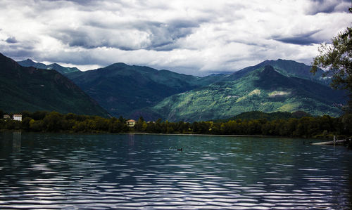 Scenic view of lake and mountains against cloudy sky