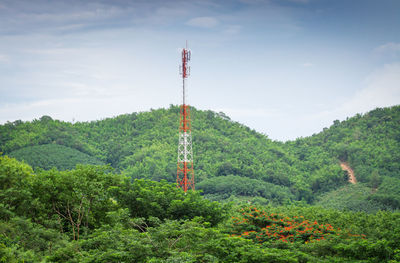 Tower amidst trees in forest against sky