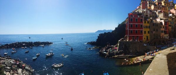 Panoramic view of sea and buildings against clear blue sky