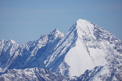 Scenic view of snowcapped mountains against clear blue sky