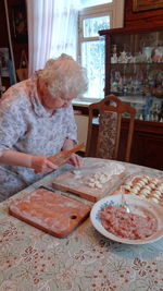 Senior woman preparing dumplings at home