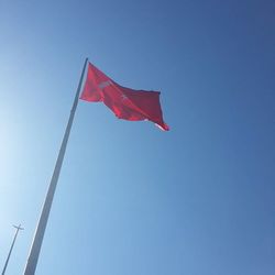 Low angle view of american flag against clear blue sky