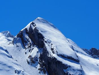 Scenic view of snowcapped mountains against clear blue sky