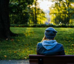 Rear view of a woman sitting on bench