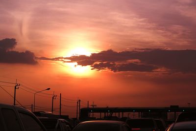Cars on bridge against sky during sunset