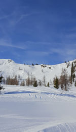 Snow covered landscape against sky