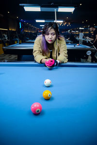 Portrait of woman playing pool