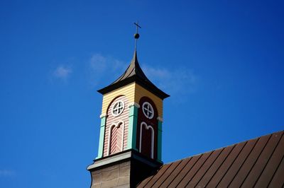 Low angle view of clock tower against blue sky