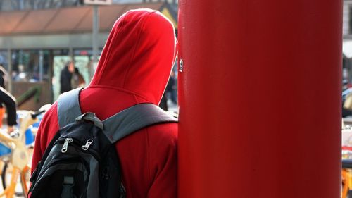 Rear view of man standing by red umbrella