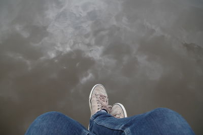 Low section of man sitting over water