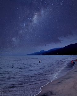 Scenic view of beach against sky at night