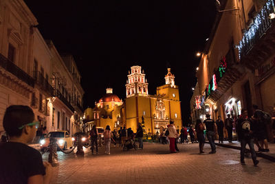 People on illuminated city at night