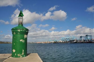 Close-up of city by sea against sky