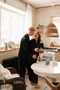 A couple in love have breakfast and drink tea in a decorated eco-style kitchen in a country house