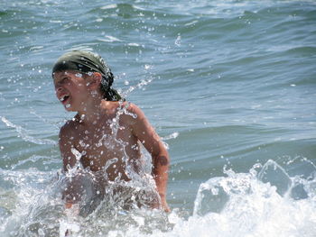 Close-up of boy enjoying in sea