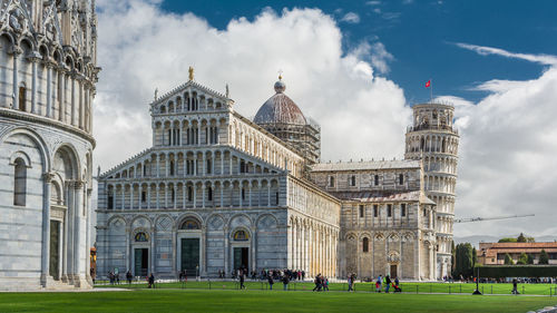 Group of people in front of historic building against sky