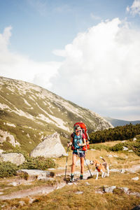 Rear view of man walking on mountain against sky