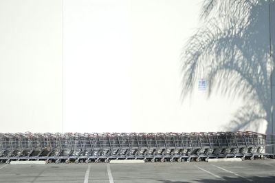 Shopping carts in parking lot against white wall