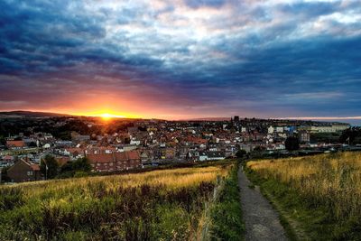 Scenic view of residential district against sky at sunset