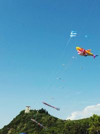 Low angle view of kite against clear blue sky