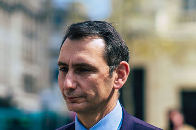 Close-up portrait of young man looking away outdoors