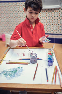 Children playing in an inner courtyard and painting with water paints