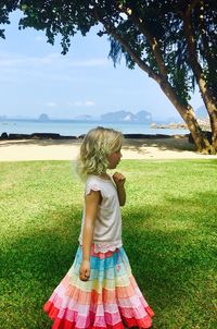 Side view of girl standing on grassy field