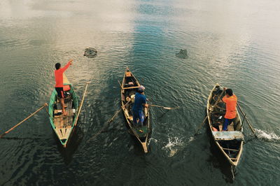 Rear view of men boating on lake