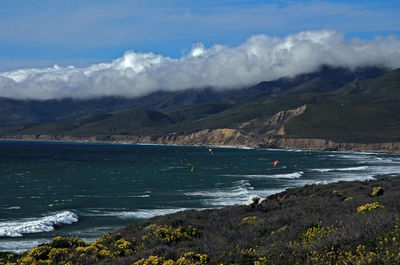 Scenic view of sea and mountains against sky