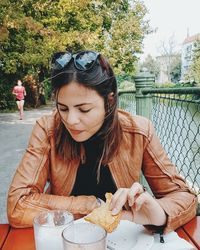 Mid adult woman eating food at outdoor cafe