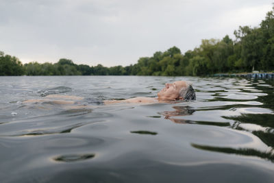 Senior man swimming in a lake