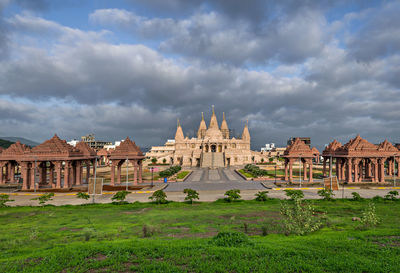 Exterior of temple on field against sky